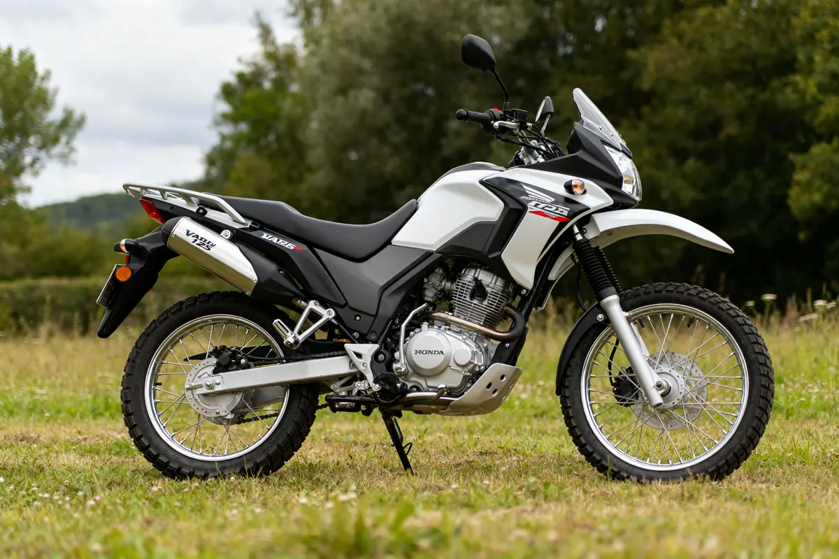 Moto blanche Honda Varadero 125 stationnée sur l'herbe en plein air