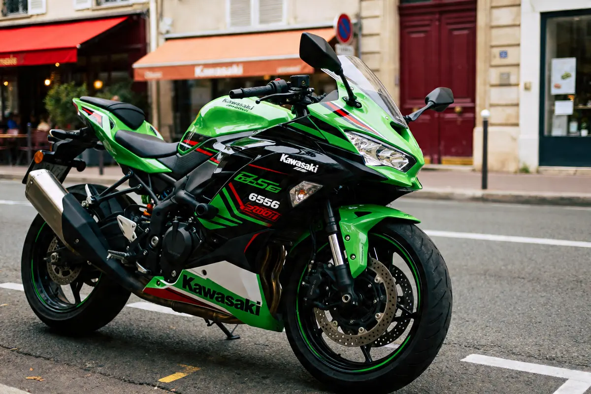Moto sportive verte Kawasaki 650 stationnée rue devant cafés et boutiques urbaines