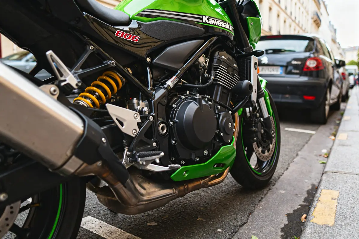 Moto verte Kawasaki ZX 800 garée en ville, moteur et amortisseur visibles
