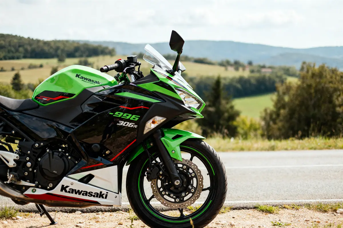 Moto sportive verte Kawasaki ninja 300r garée sur une route de campagne