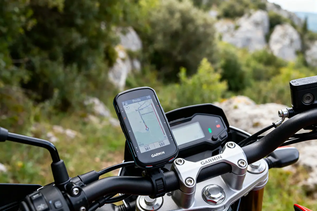 Guidon de moto avec GPS moto Garmin en affichage cartographique sur route pittoresque.