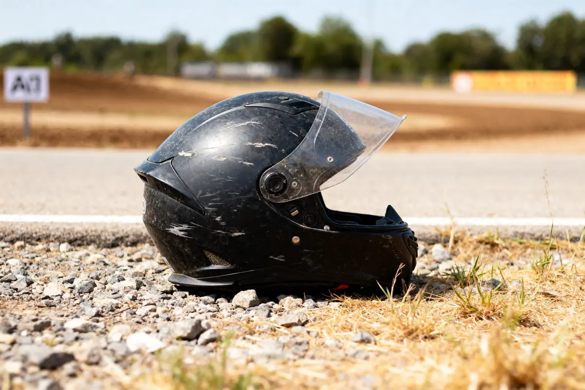 Casque moto usé au sol sur piste terreuse, marque de casque moto à éviter