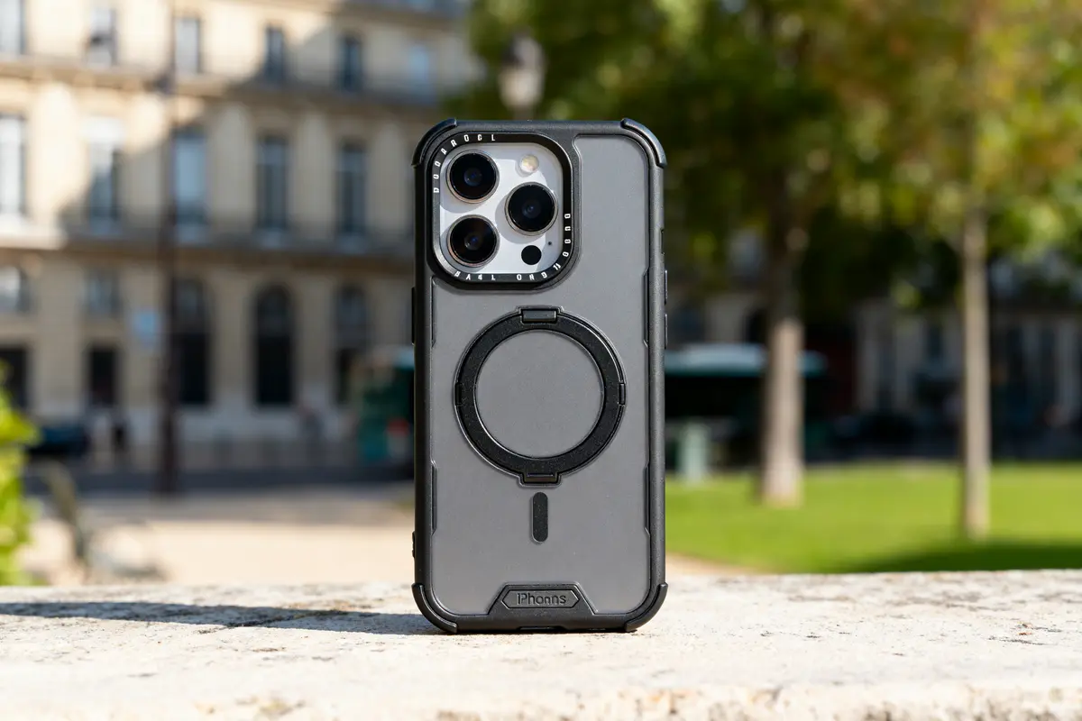 Coque compatible Quad Lock iPhone 16 posée sur un rebord en extérieur urbain