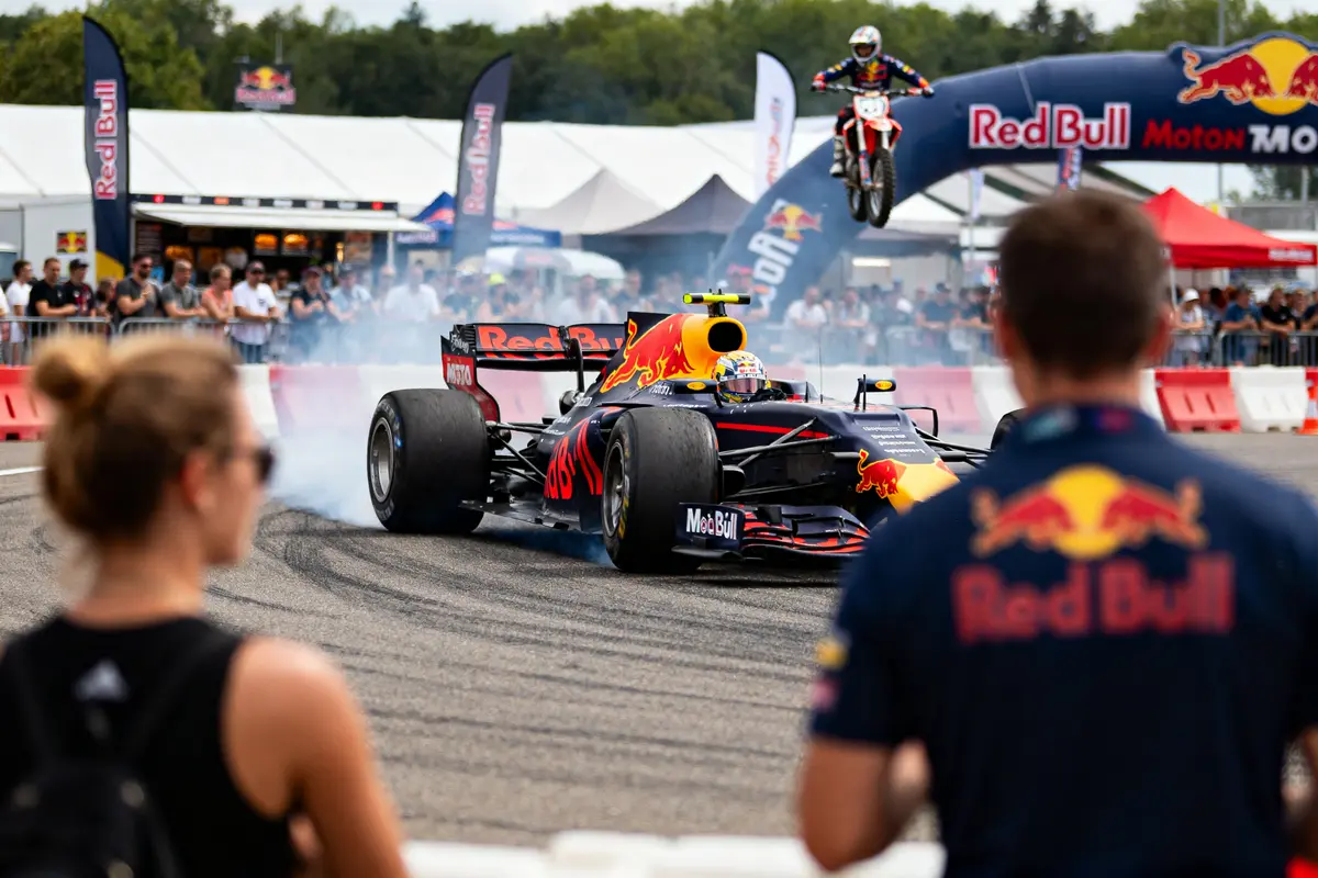 Formule 1 Red Bull et moto sautent pendant Red Bull Motormania avec spectateurs présents