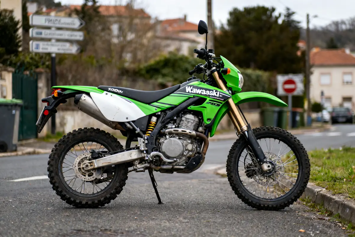 Moto verte Kawasaki 1000 sx kawa stationnée sur route avec panneau en arrière-plan