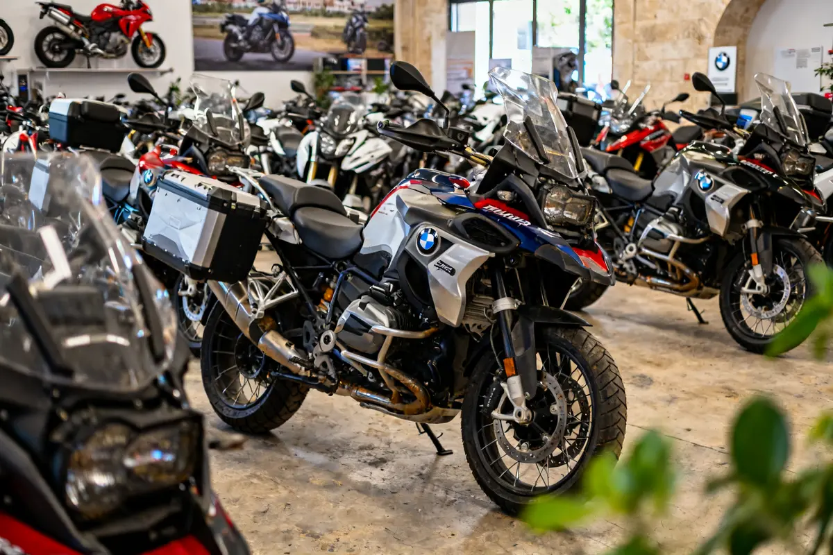 Salle d'exposition avec plusieurs motos BMW à Avignon, dont une en gros plan.