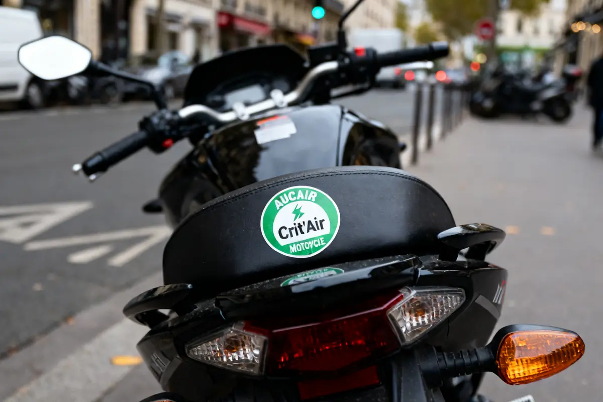 Motocyclette avec vignette crit air motorcycle garée en ville sur une rue passante