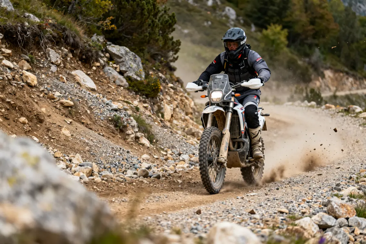 Motard aventurier conduisant une moto mountain sur un chemin de terre caillouteux