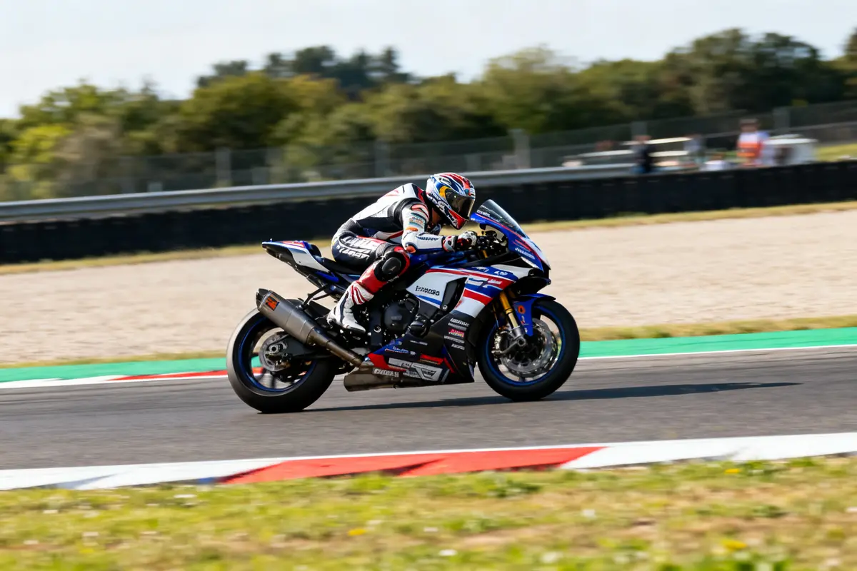 Pilote en combinaison sur motorcycle 2 Yamaha racing sur circuit asphalté en pleine course