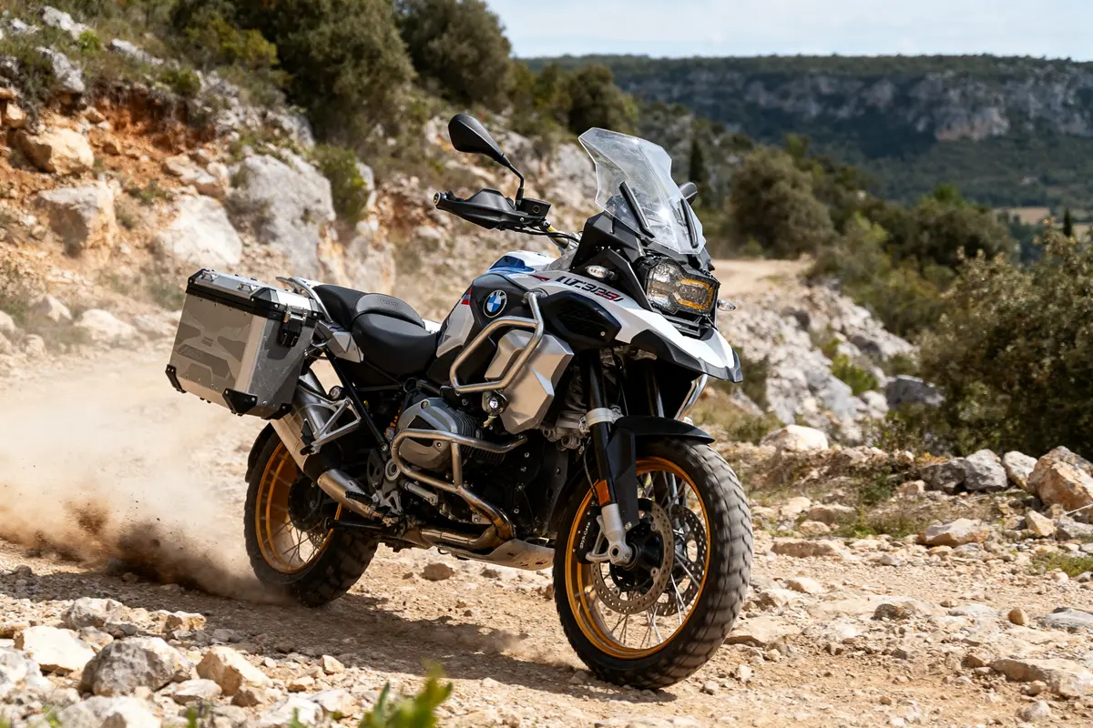 Moto BMW R 1300 GS Adventure sur un chemin rocheux en pleine nature.