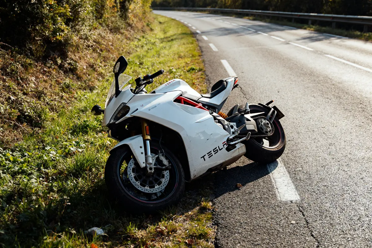 Moto électrique Tesla blanche garée sur le bord d'une route ensoleillée