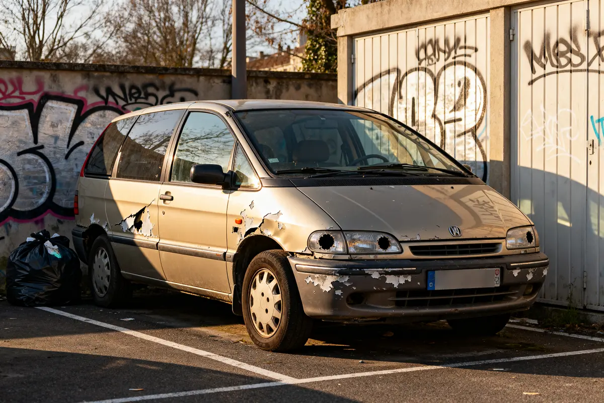 Minivan vieux et délabré stationné, souvent considéré comme la pire voiture du monde