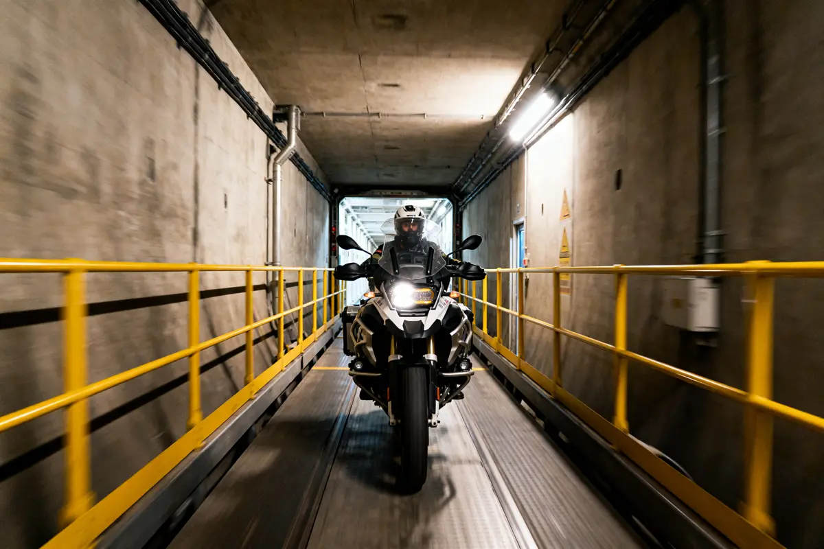 Motard traversant le tunnel sous la Manche à moto éclairée par des lumières intérieures.