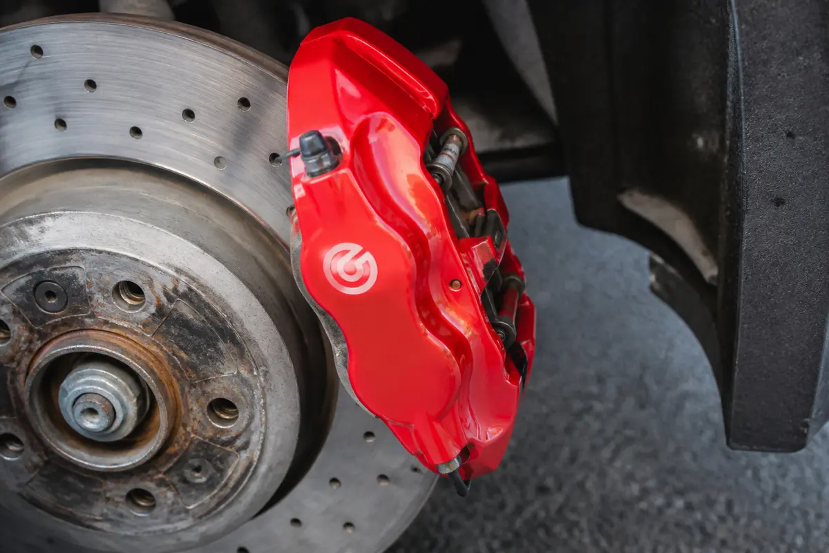 Étrier de frein rouge avec disque ventilé sur une voiture. Design sportif et performant.